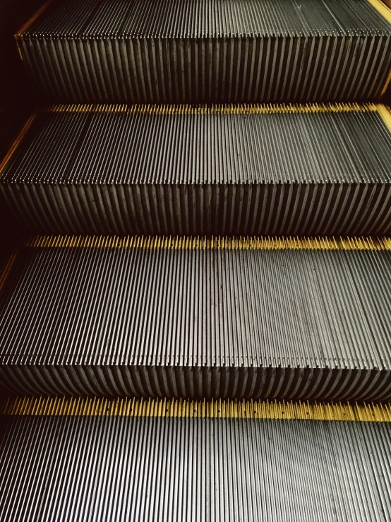 three rows of metal stairs with yellow slats