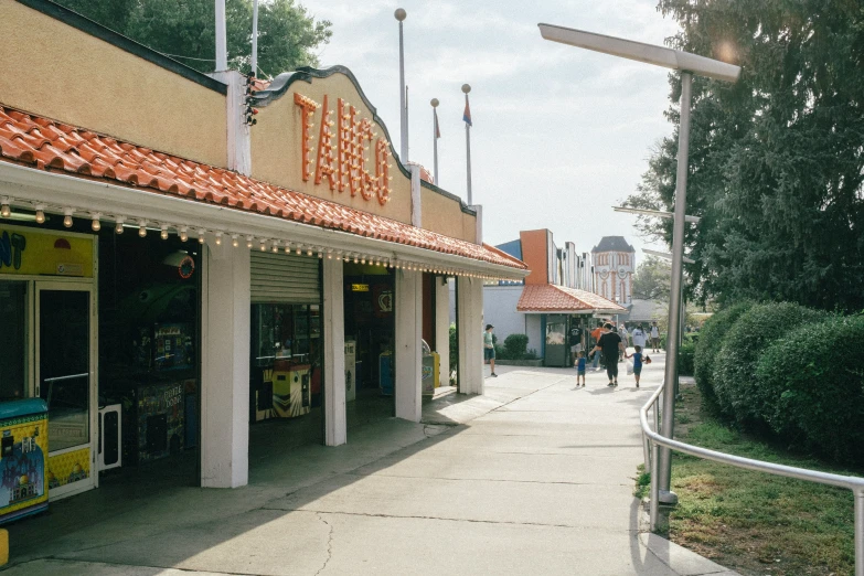 a small shop with a bunch of people walking by it