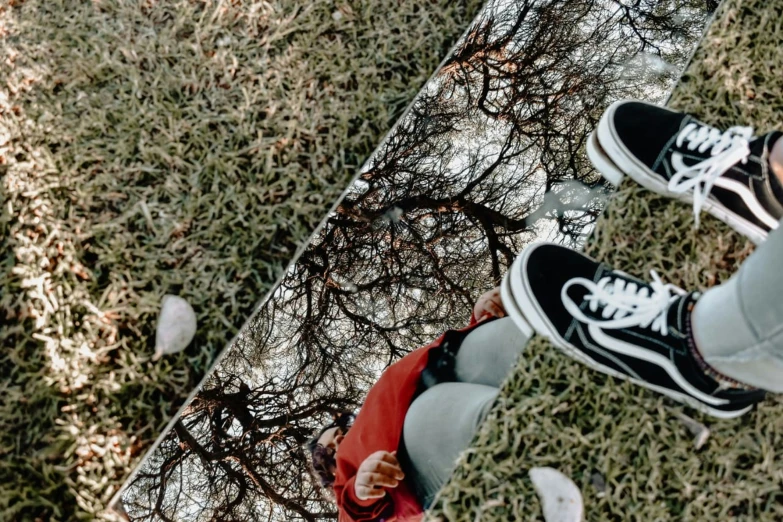 view of two persons standing on a skate board