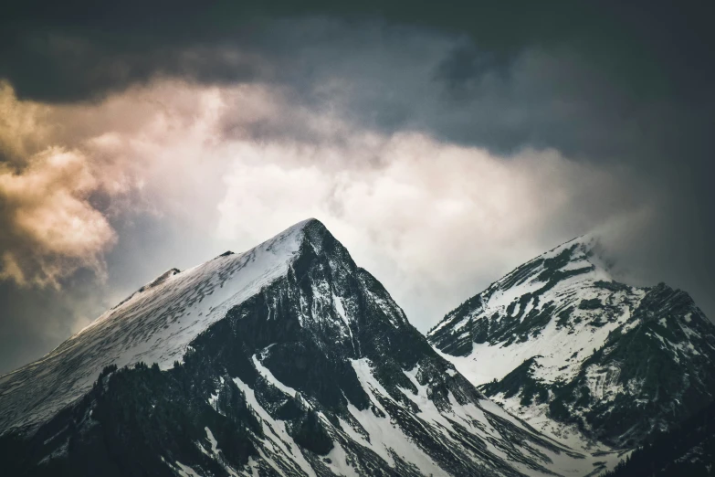 the peak of a mountain under a cloudy sky