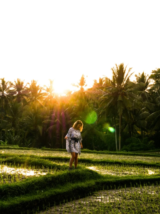 a young woman standing in the middle of a field