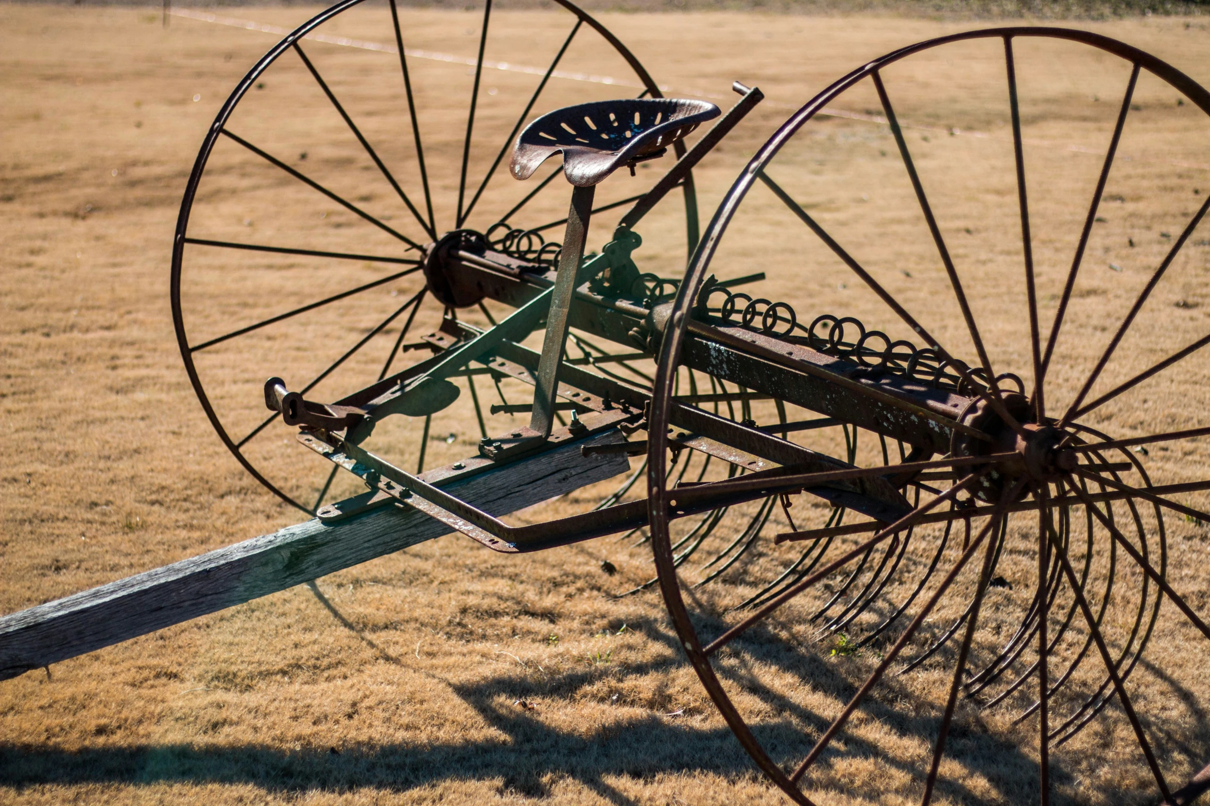 an antique wheel in a dry field that is still intact