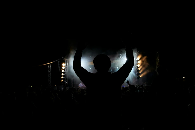 a silhouetted person is in front of a crowd