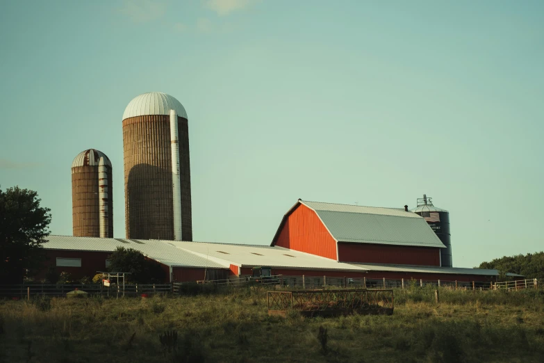 a large red barn and two silos on top of it