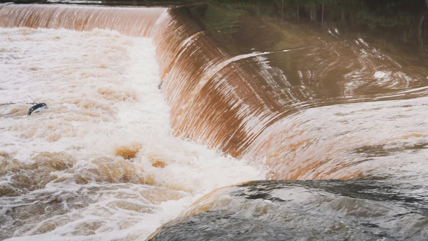 person surfing on a high wave at a dam