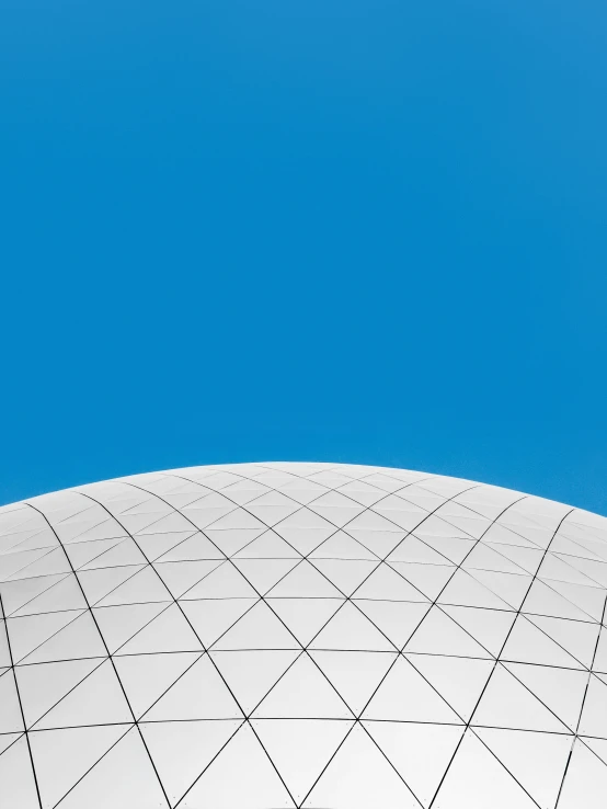 the top of a building with a white structure against a blue sky