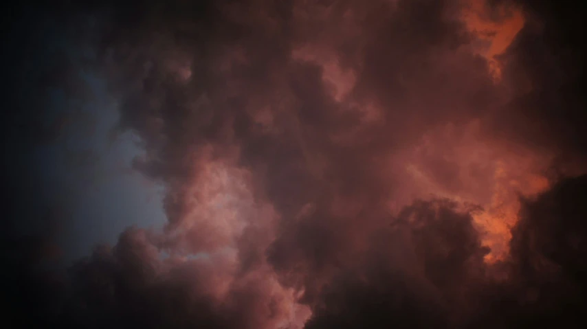 a dark sky and some very fluffy clouds