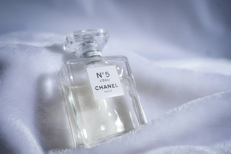 an open bottle of perfume on white fur