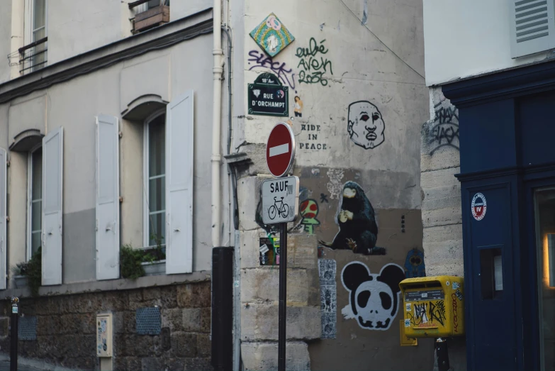 a street corner with different types of street art on the wall