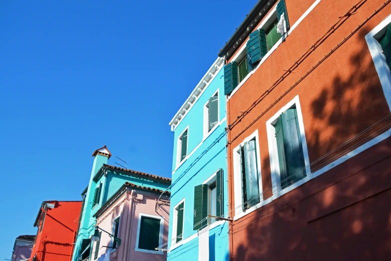 a street in a town with several buildings and green shutters