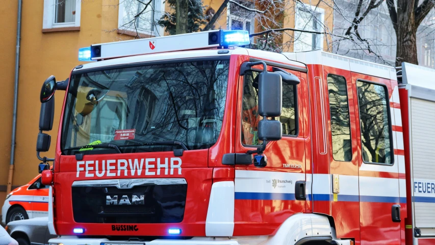 an firetruck with its lights on sitting in front of buildings