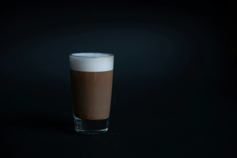 a glass cup is sitting on a black table