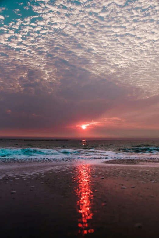 the sun is setting over the ocean at beach