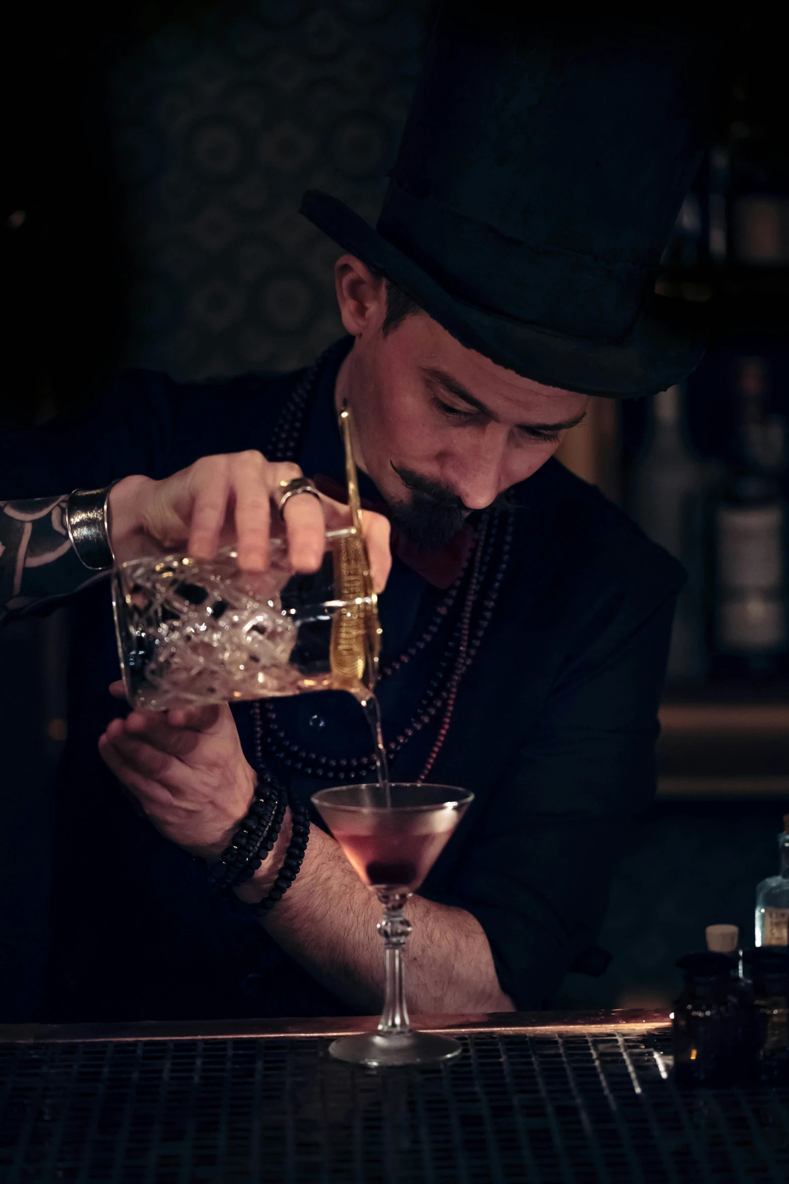 a bartender makes cocktail with a bottle in the corner