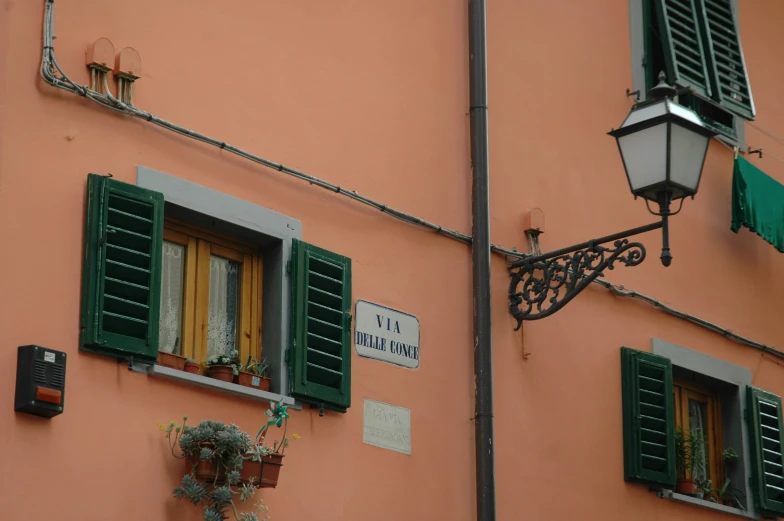 several windows and a street lamp on an orange building