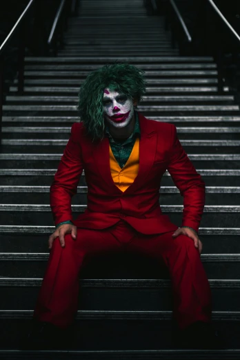 a man dressed as joker sitting on a stairway