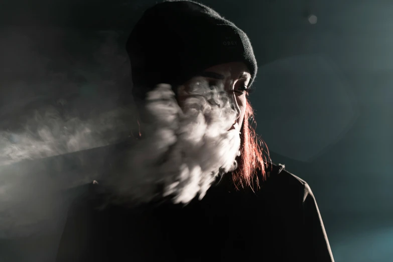 a man with large, red colored smoke in his mouth