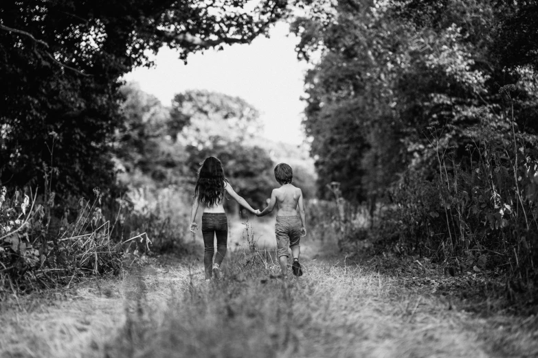 two people walking in an open area with a tree