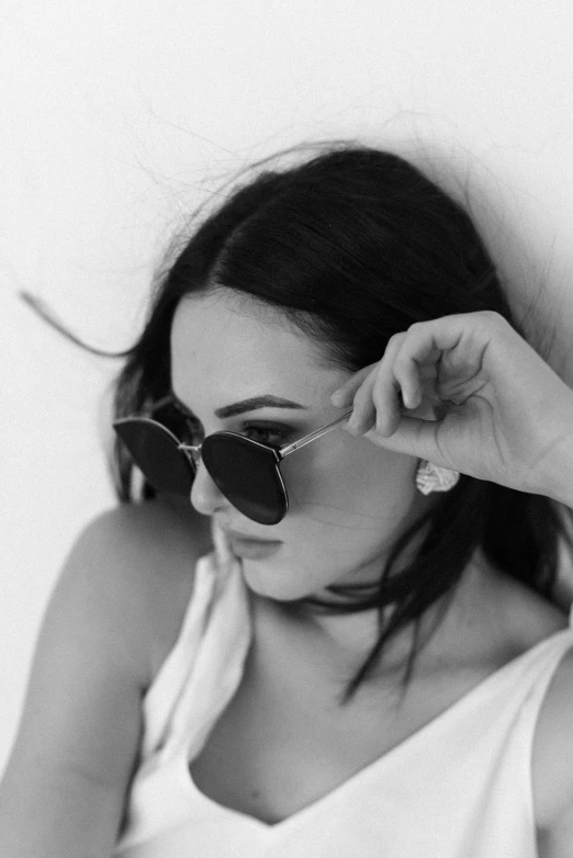 a young woman wearing sunglasses poses for a black and white po