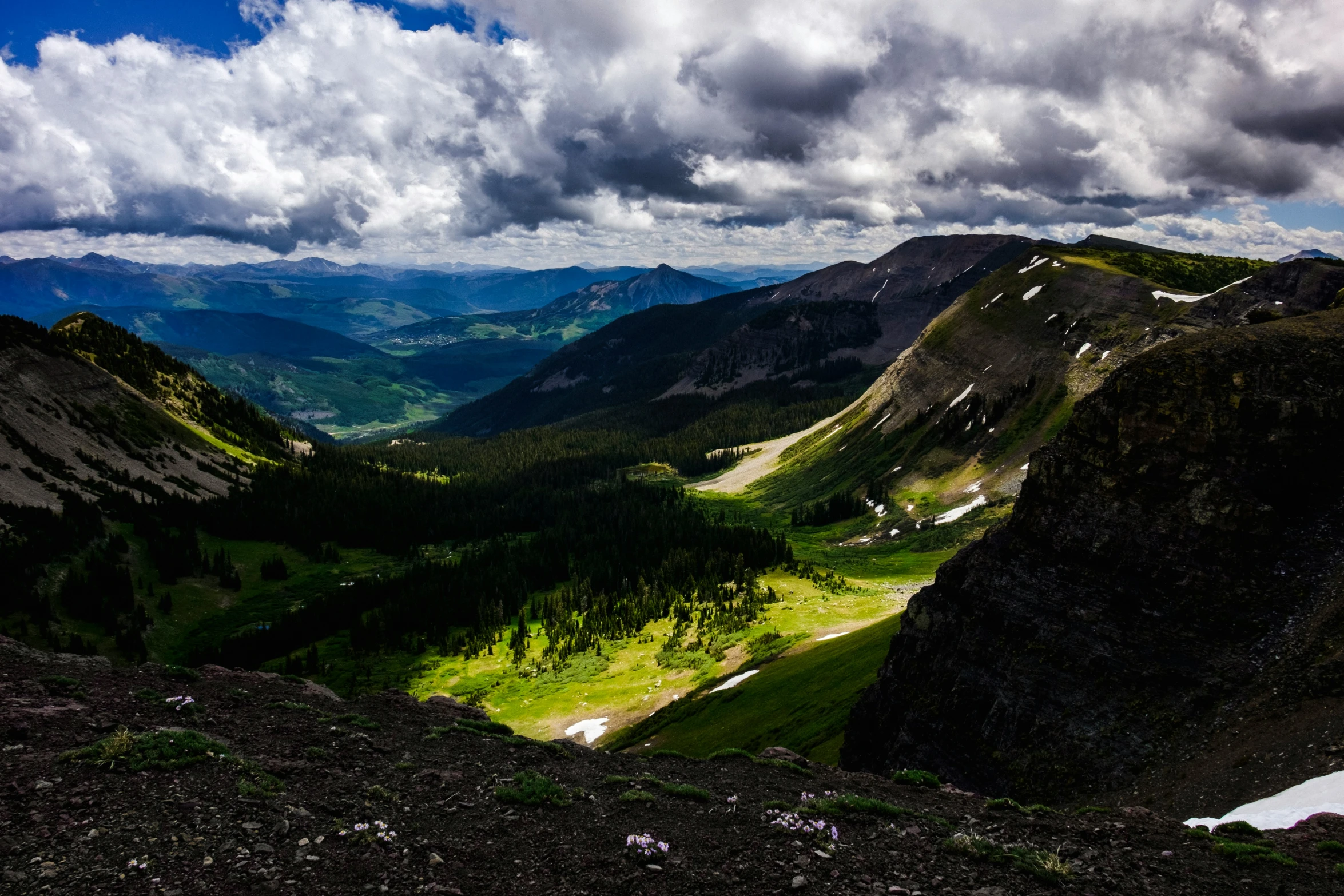 a view looking down from the mountain with clouds above