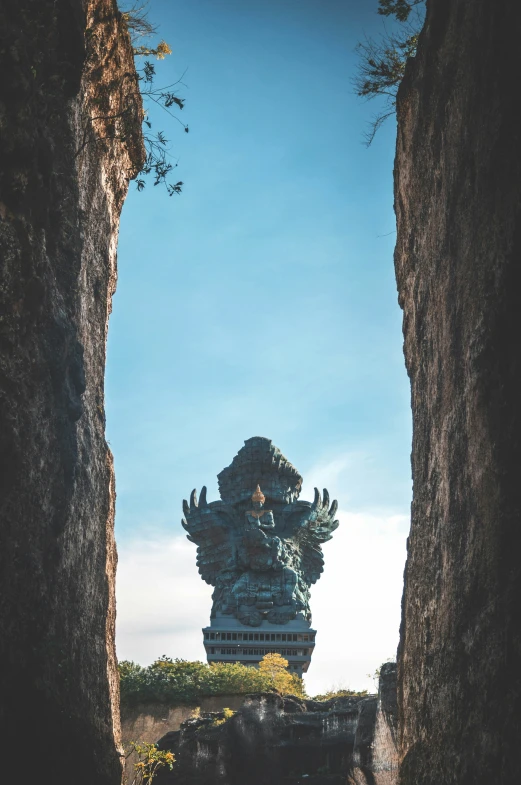 a large statue is standing between two stone walls