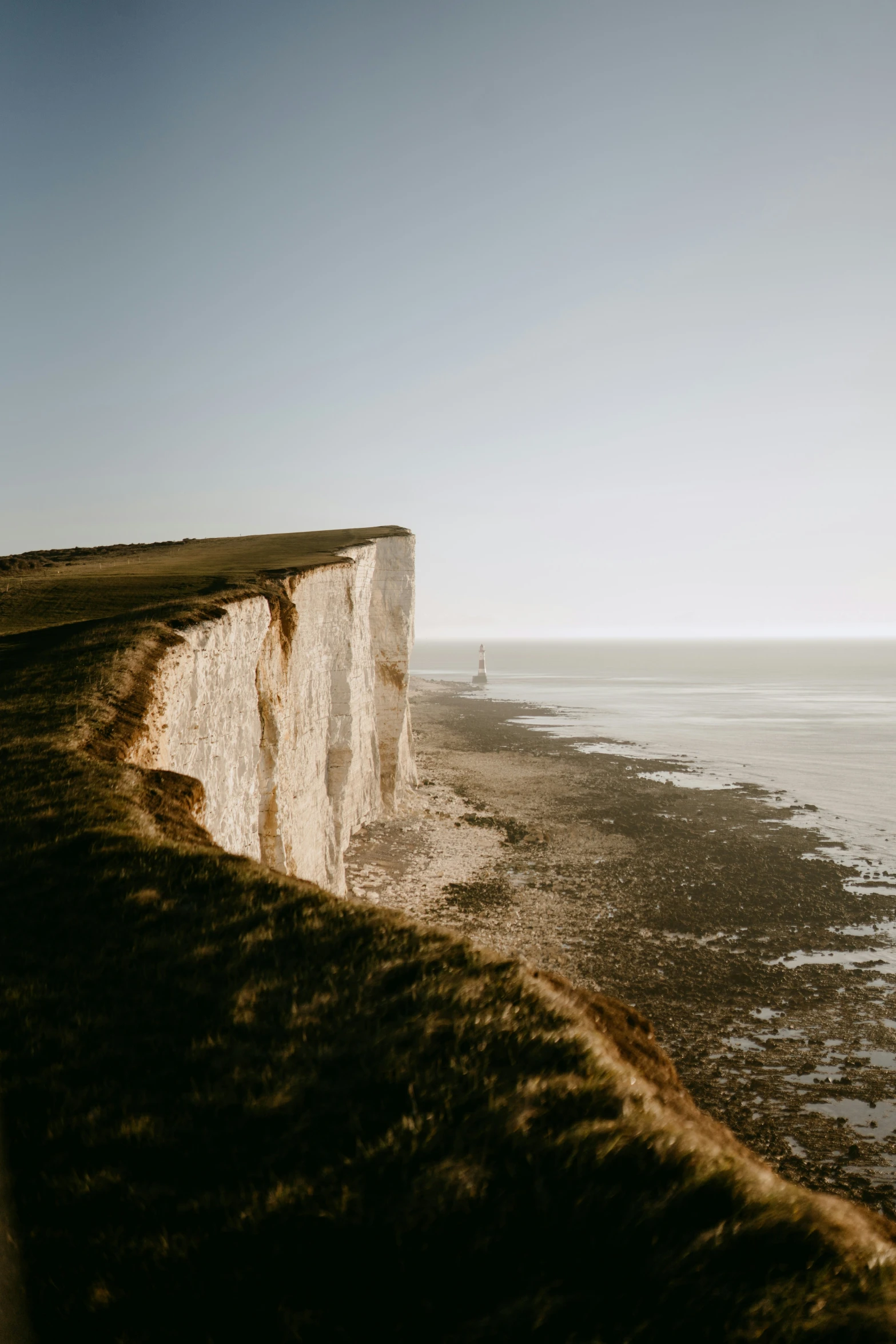 a person riding a surfboard on the edge of a cliff overlooking the water