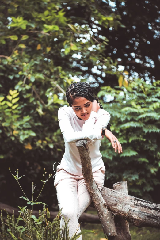 a woman leaning on the end of a fence