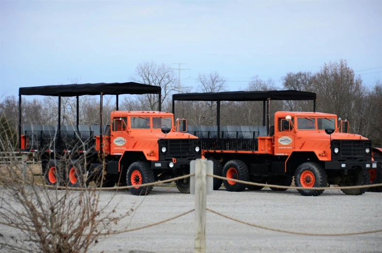 three orange trucks in line with their seats