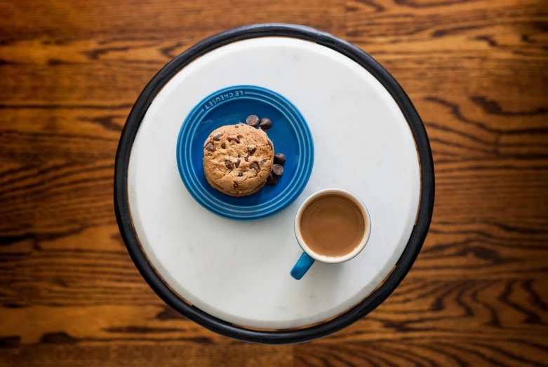 plate with blue bowl with chocolate chip cookie and coffee