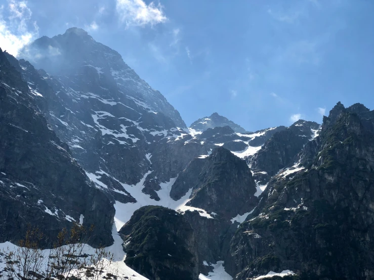 some snow and mountains under a blue cloudy sky