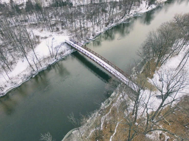 a bridge crossing a river covered in snow