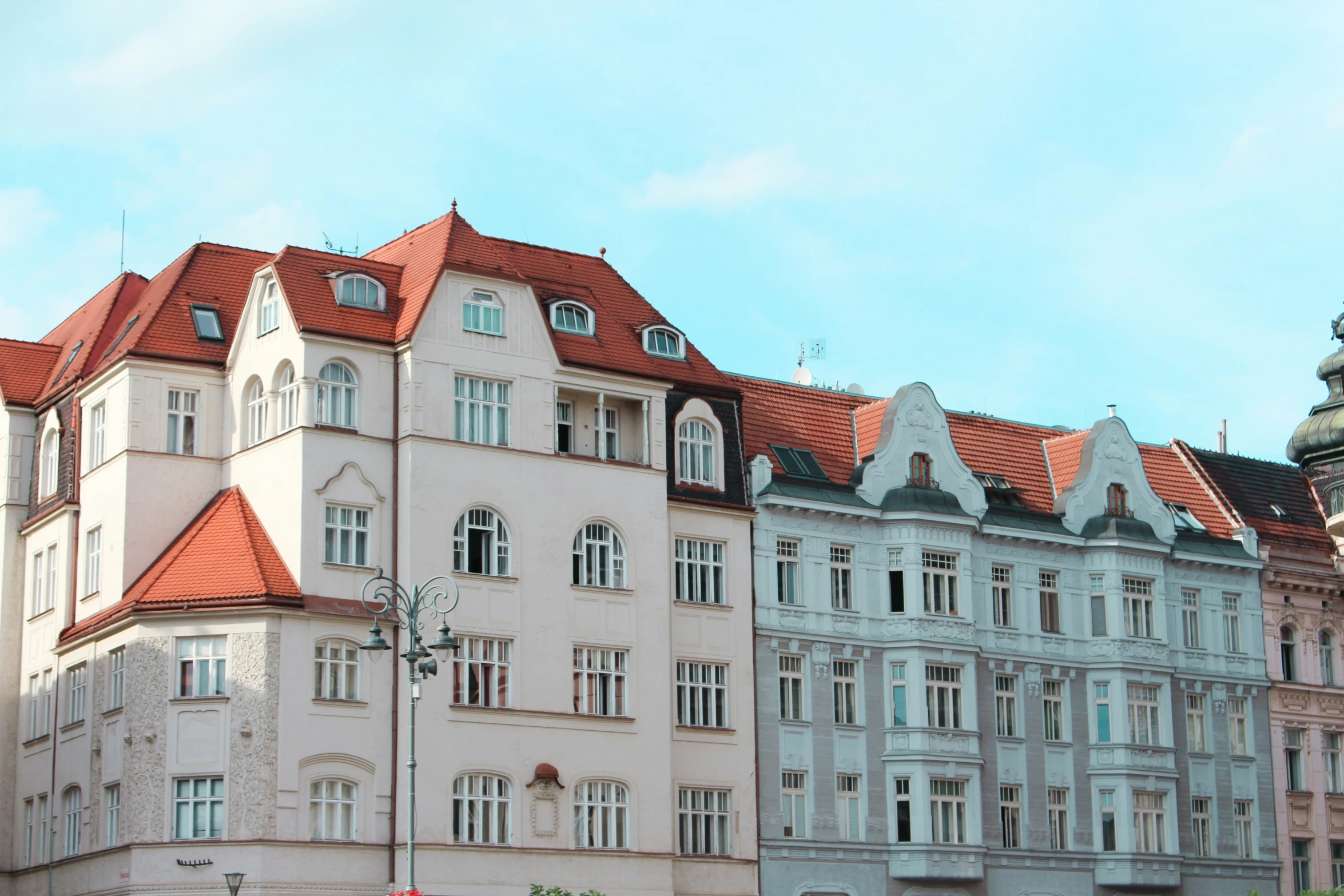 several old white buildings are on a sunny day