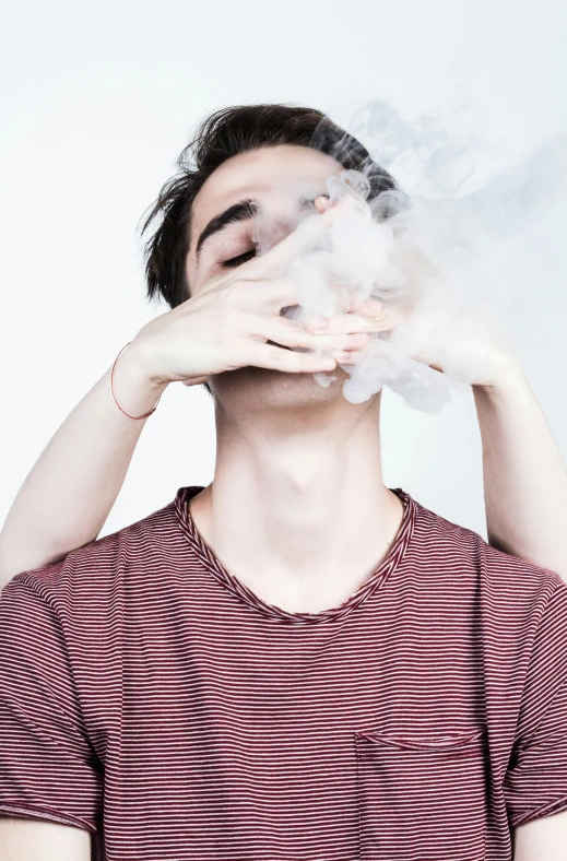 a person standing holding steam above their mouth