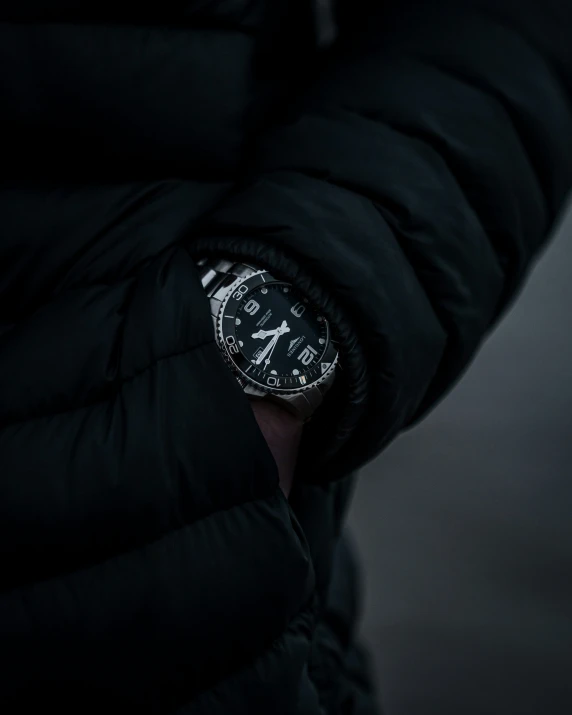 a black and white clock attached to the inside of a man's jacket