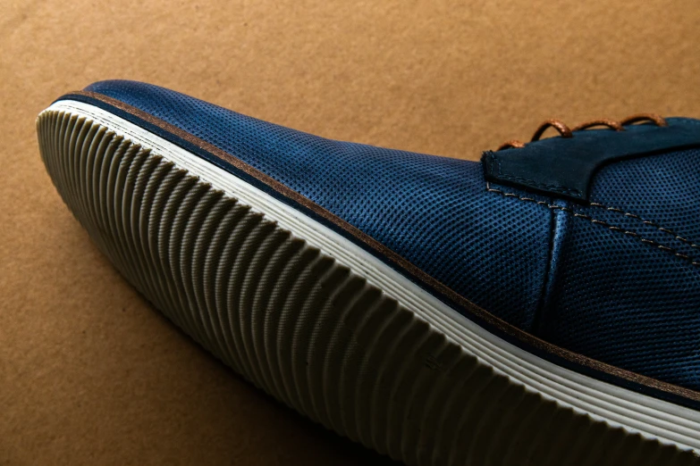 a shoe that has a toe covered in brown and blue fabric