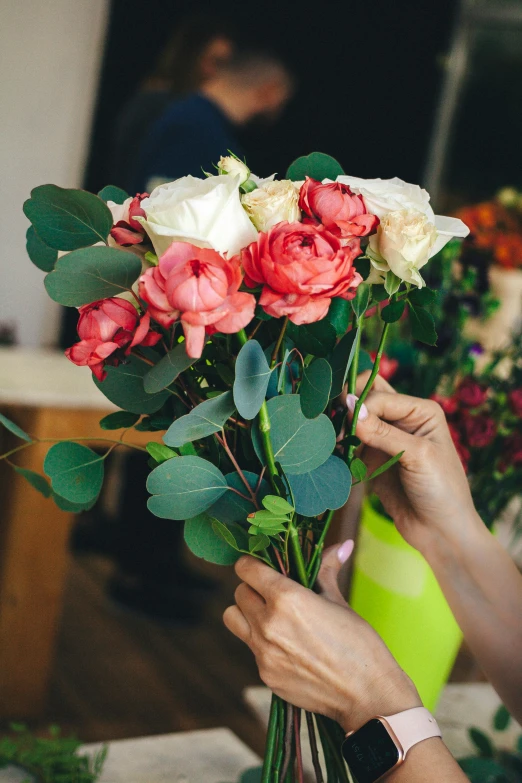 a woman is trimming flowers to the end of a bouquet