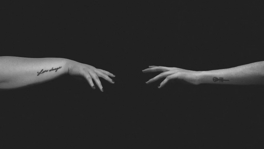 two female hands in the dark are touching each other