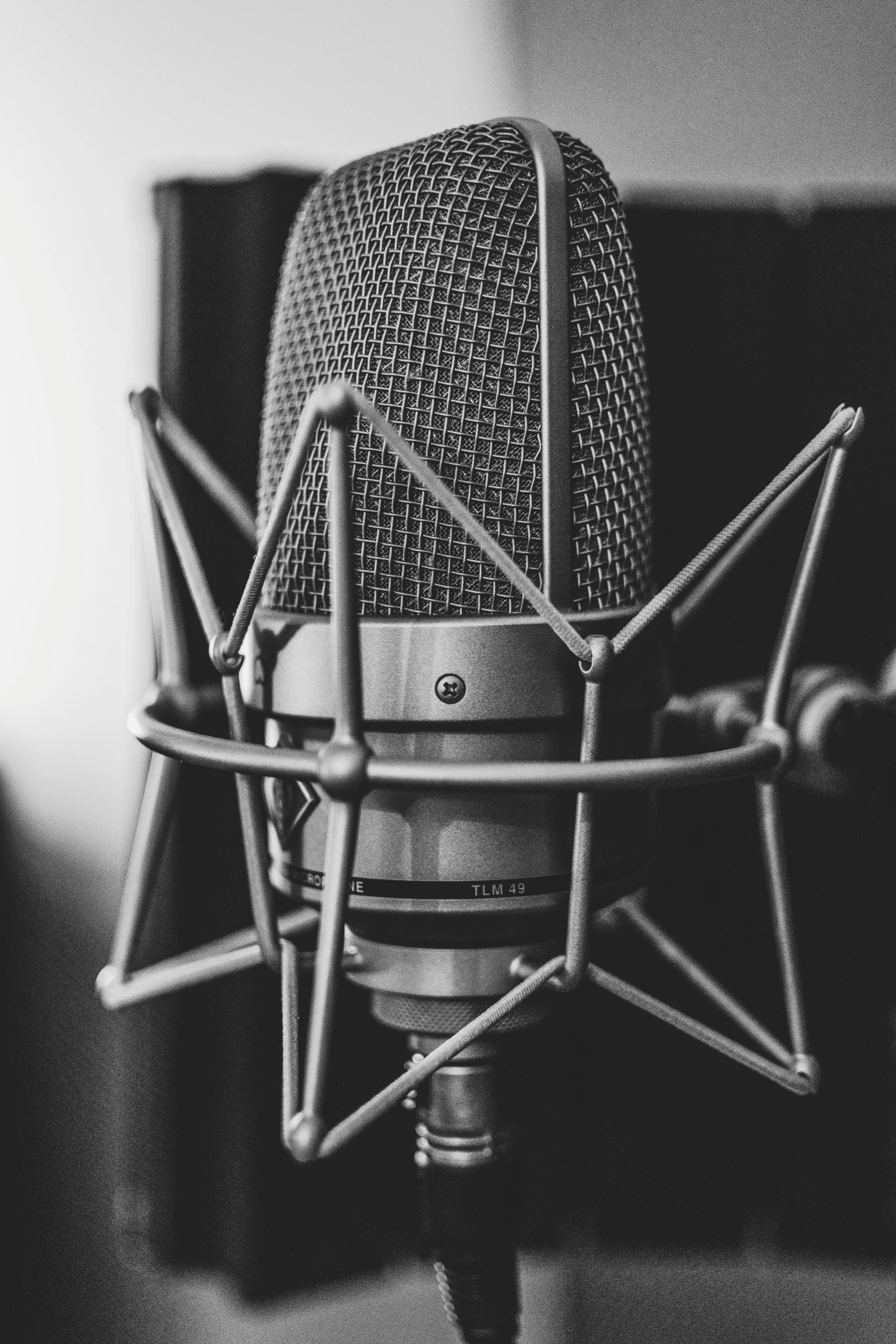 a black and white image of a microphone in a studio