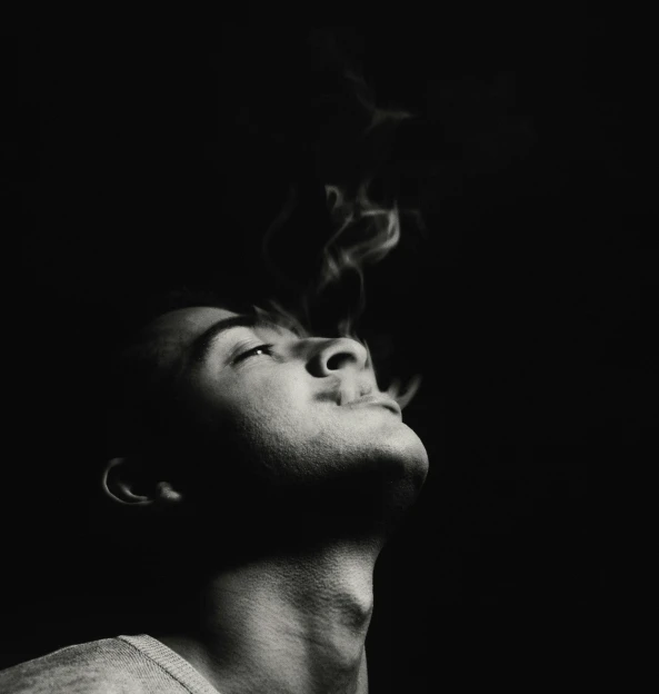 black and white pograph of a man smoking a cigarette