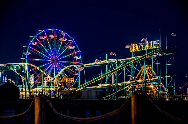 a colorful carnival ferris wheel sitting next to a ferris wheel