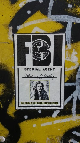 a poster hanging on the side of a yellow wall