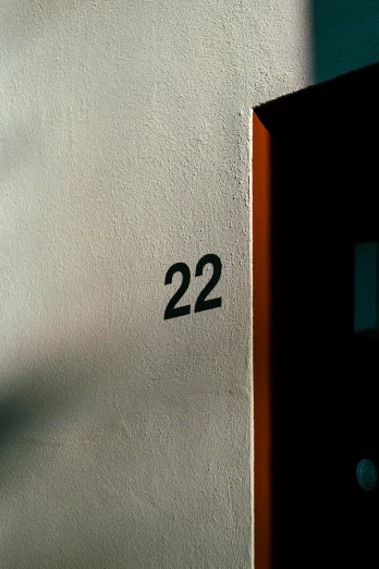 a black door next to a white wall and the number twenty