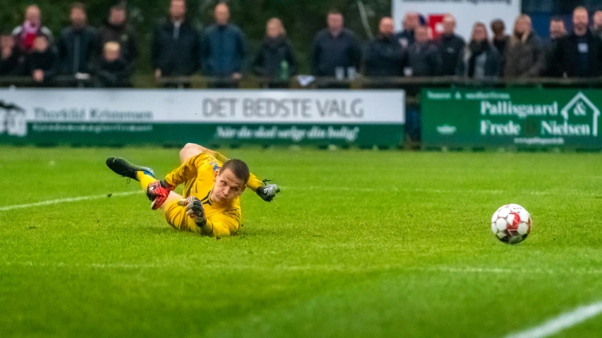 a soccer player lays on the grass during a game