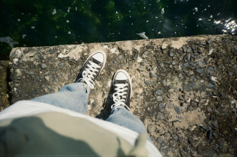 person standing at edge of walkway that has rocks all over