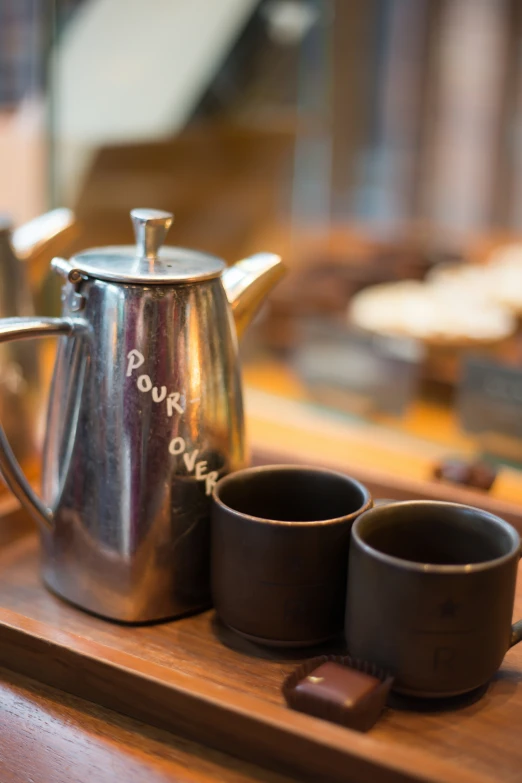 some cups sit in a tea pot, with the bottom half covered