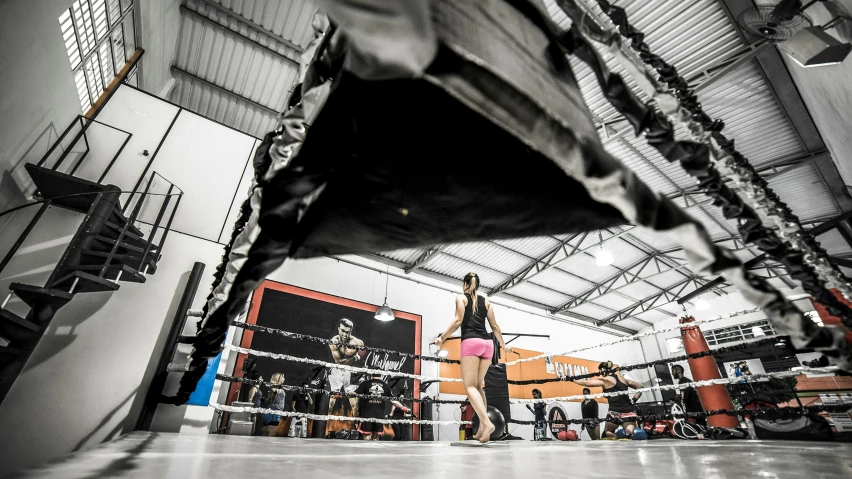 a girl holding a boxing ring in the middle of an indoor arena