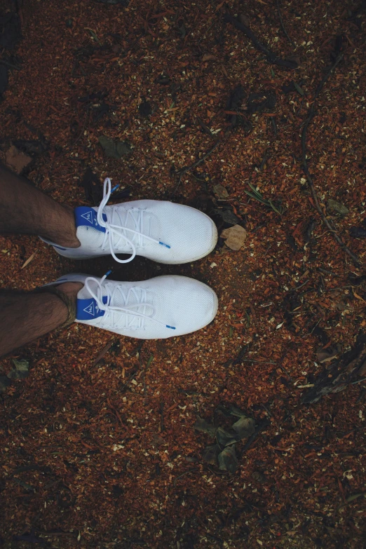 a person standing on dirt ground with their feet crossed