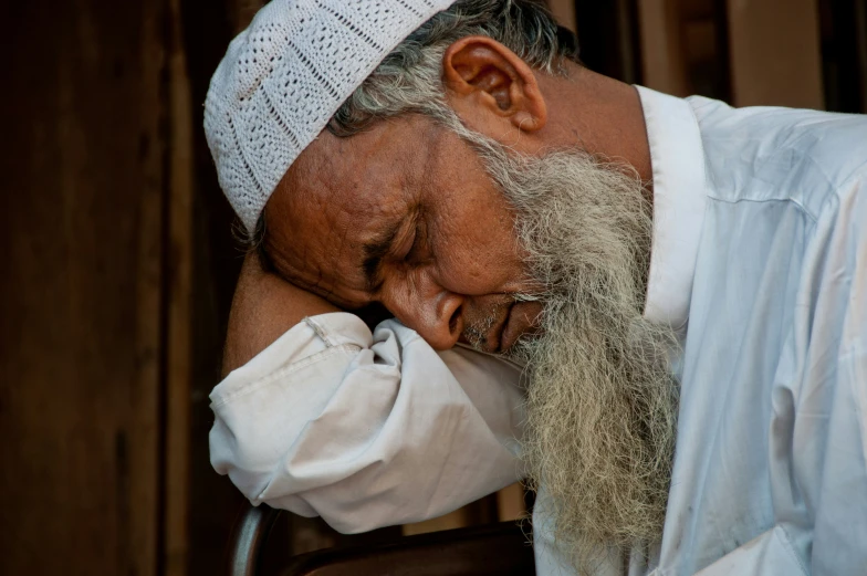 a man with a large white beard and long hair sleeping