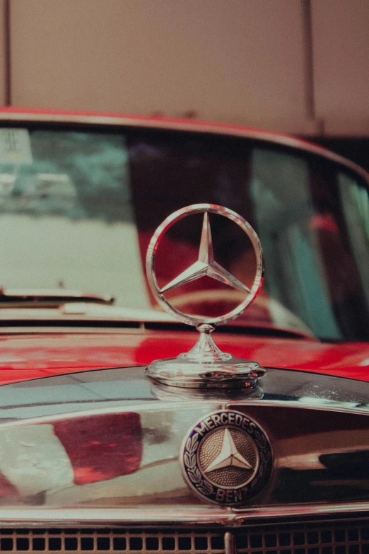 a mercedes logo is shown on an old style red car