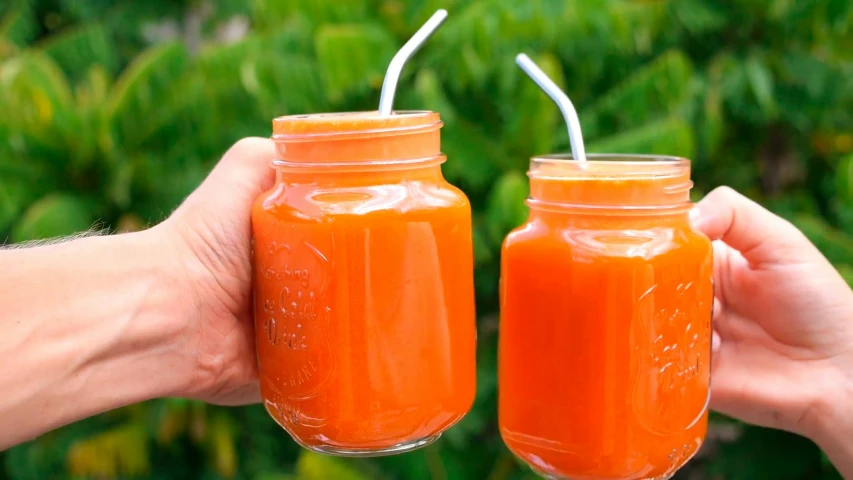 a person holds two jars filled with liquid